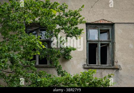 Two shattered windows in an old, abandoned house. Stock Photo