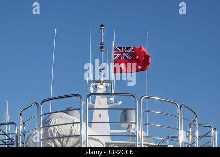 Australian red ensign flag, official merchant ship maritime symbol, fluttering on mast of boat Stock Photo