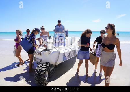 People getting off onto a Beach from a Tender Boat Stock Photo