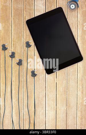 Tablet and plugs on wooden background Stock Photo