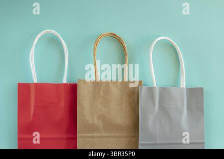 Three shopping bags in a row on a colored background Stock Photo