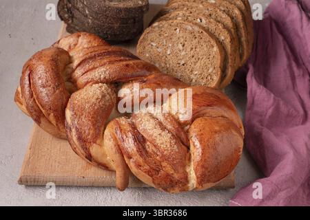 There are different types of bread on a wooden board Stock Photo