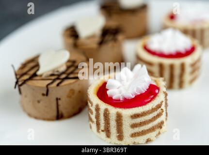 Small cakes with different fillings on a white plate close-up Stock Photo