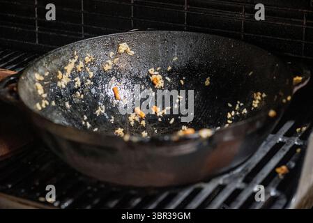 abandoned on the grill  dirty cast iron pan, night scene, no people Stock Photo