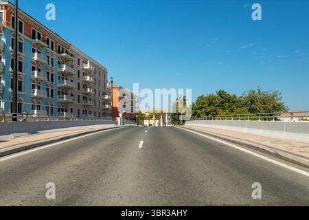 an empty paved road , beautiful street with modern residential houses in summer sunny day Stock Photo