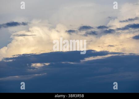 Bluish afternoon sky with dramatic dark and white clouds floating. Capturing the essence of bad weather and stormy atmospheric conditions. Stock Photo