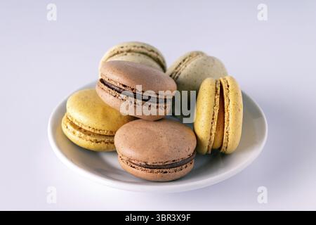 Colored macaroons in a plate on a white background, close-up Stock Photo