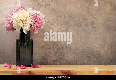 Abstract floral arrangement, empty wooden table and fresh peony flowers in vase, stage for product display and business concept. Minimal modern aesthe Stock Photo