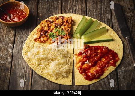 Tortilla wraps sandwiches with fresh vegetables, minced meat and on wooden background. Burrito, sandwich wrap, fajita wrap Stock Photo