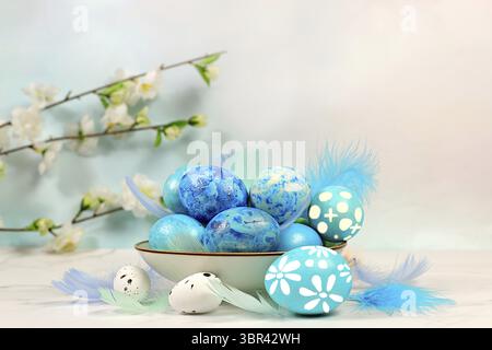 Happy Easter concept. Abstract Easter composition with blue decorated eggs, feathers, flowering branches and flowers. Banner for screen with space for Stock Photo