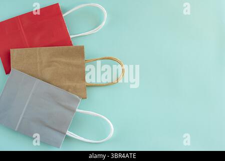 Empty paper shopping bags isolated on light blue background. Top view Stock Photo