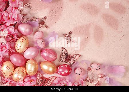 Happy Easter concept. Abstract spring Easter composition with pink painted eggs, feathers, butterflies, flowering branches and flowers. Banner for the Stock Photo