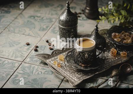 Coffee in metal Turkish traditional cup and coffee beans on tile background Stock Photo