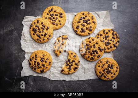 Homemade Chocolate chip cookies on paper over dark background, top view Stock Photo