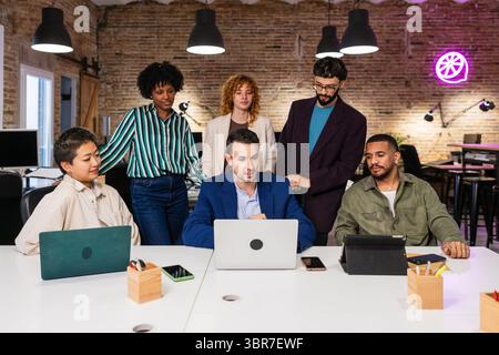 Marketing team working together on a project using laptop in the office Stock Photo