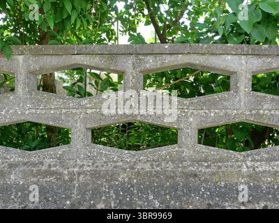 Concrete privacy wall with hexagonal holes. 1980s East German retro style. Ideal as background. Copy space. Stock Photo