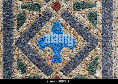Geometric Mosaic Patterns at National Zoo Reptile Discovery Center in Washington DC | WASHINGTON D.C., United States — A blue trefoil set within a diamond of green and gray stone anchors this detail of the columned entrance at the National Zoo's Reptile Discovery Center, an Earley Process mosaic dating to 1931. John Joseph Earley created the coloring by embedding crushed colored stone into white Portland cement and exposing it before the concrete cured fully, a technique he pioneered in Washington in the 1910s and 1920s. The ornate portico has since been dismantled and placed in storage pendin Stock Photo