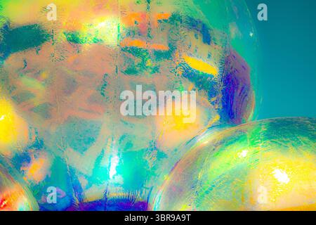 A vibrant, abstract artwork featuring a close-up of a shiny, surface reflecting multicolored light. The dominant hues are red, orange, yellow, and pin Stock Photo