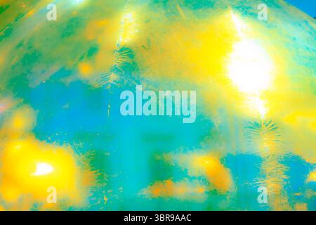 A vibrant, abstract artwork featuring a close-up of a shiny, surface reflecting multicolored light. The dominant hues are red, orange, yellow, and pin Stock Photo