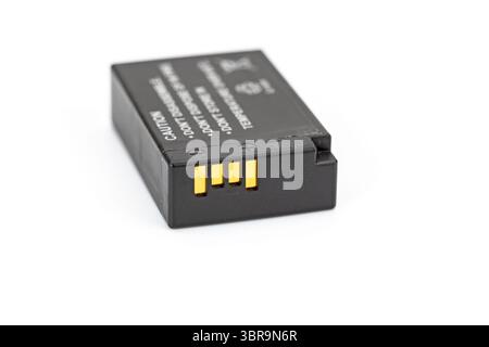 A Li-ion camera battery is shown in closeup, highlighting its connectors against white background. image focuses on battery details Stock Photo