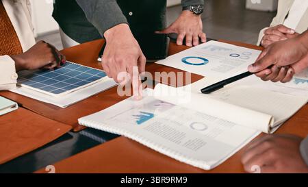 Team Members Collaborating on Financial Reports and Data Analysis in a Professional Meeting Stock Photo