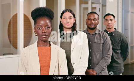 Diverse Group of Professionals Standing Confidently in an Office Setting Stock Photo