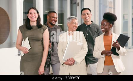 Diverse Group of Professionals Smiling and Interacting in a Modern Office Setting Stock Photo