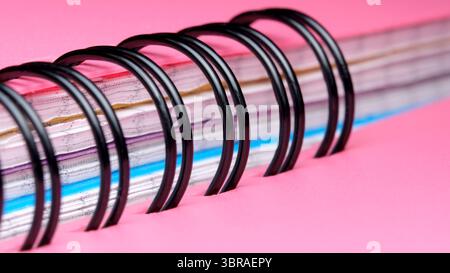 A close-up view of a spiral notebook features vibrant pages and rings. Stock Photo