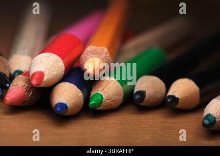 Vibrant colored pencils arranged together on a wooden surface. Stock Photo