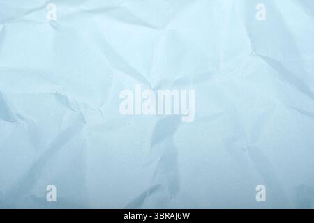 A crumpled light blue surface captures soft natural light beautifully. Stock Photo