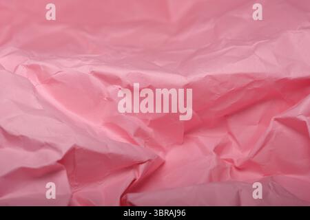 Crumpled pink paper adds a delicate touch to the creative workspace. Stock Photo