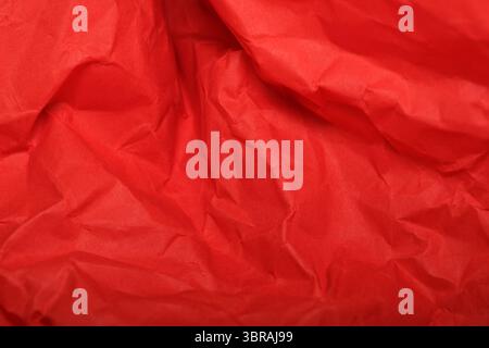 Rich and vivid red paper showcases intricate folds and textures, inviting touch. Stock Photo