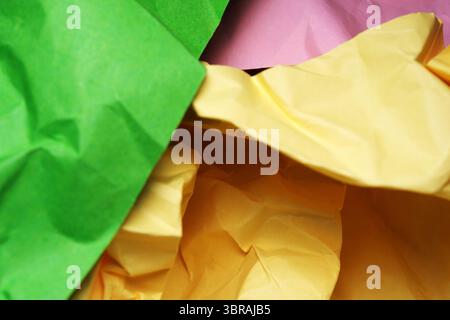 Vibrant sheets of crumpled paper intermingle in a delightful arrangement. Stock Photo