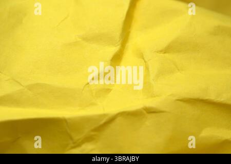 A close-up view of crumpled yellow paper reveals its warm, textured beauty. Stock Photo