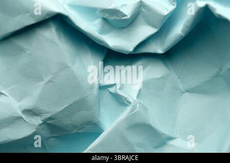 Crumpled turquoise paper offers inviting texture for artistic inspiration. Stock Photo
