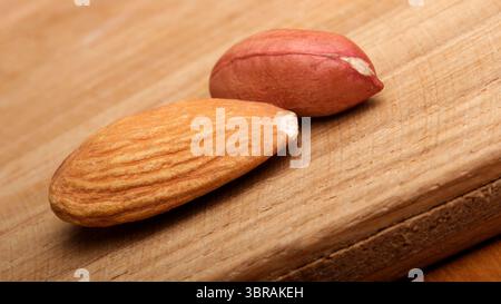 Two nuts on a warm wooden surface showcase their textures and colors. Stock Photo