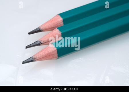 Three vibrant colored pencils sit on a glossy surface, ready for creativity. Stock Photo