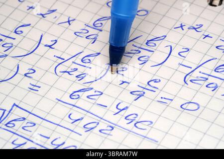 Multiple mathematical equations are intricately written in a notebook. Stock Photo