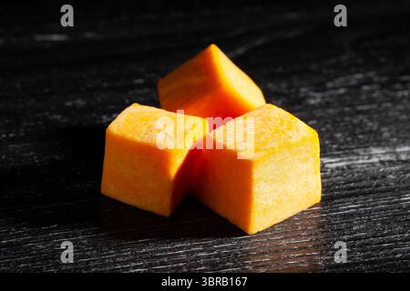 squash chunks on black wood background Stock Photo