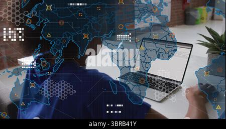 IT professional woman coding on laptop at desk in office, with digital world map overlay Stock Photo