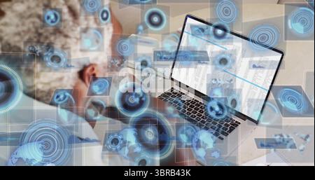 Leaning analyst analyzing spreadsheets on laptop at desk with UI graphics, copy space Stock Photo