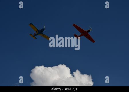 Two aerobatic planes fly in formation above cumulus clouds during an airshow at Ghimbav airfield. Stock Photo