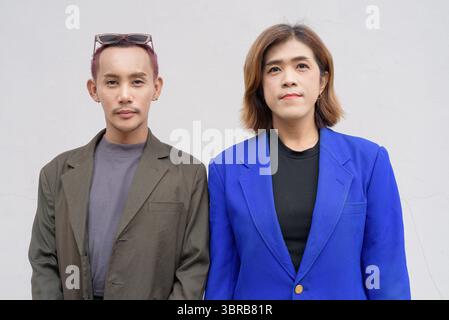 Gender inclusive Asian business team couple against white background Stock Photo