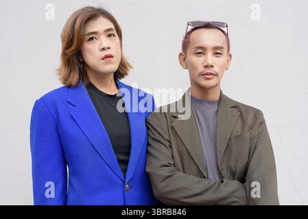 Gender inclusive Asian business team couple against white background Stock Photo
