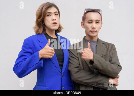 Gender inclusive Asian business team couple against white background Stock Photo