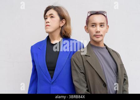 Gender inclusive Asian business team couple against white background Stock Photo