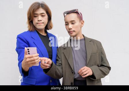 Gender inclusive Asian business team couple against white background Stock Photo