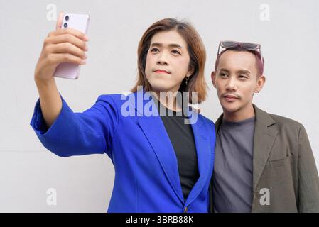 Gender inclusive Asian business team couple against white background Stock Photo