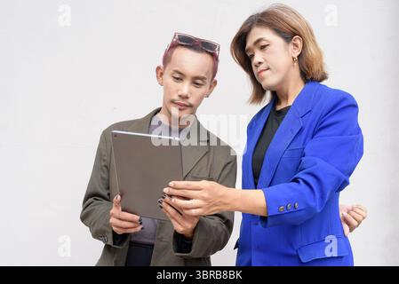 Gender inclusive Asian business team couple against white background Stock Photo
