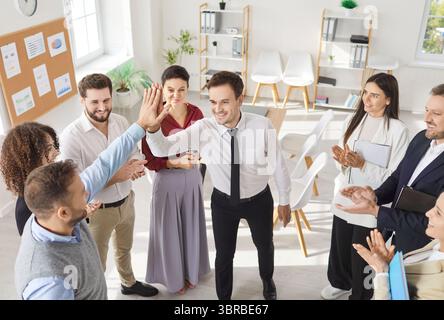 Group of business people standing in circle and making high five gesture as agreement  Stock Photo